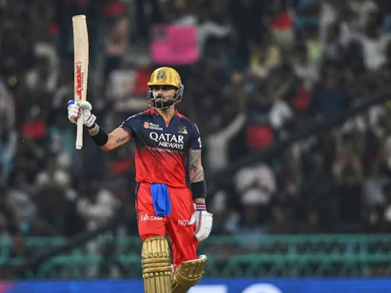 Virat Kohli celebrating his half-century against LSG in IPL 2025, praised by Dinesh Karthik.