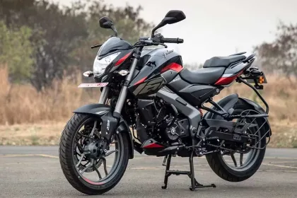 Bajaj Pulsar NS160 in Cocktail Wine Red parked on city street with sharp LED headlamp