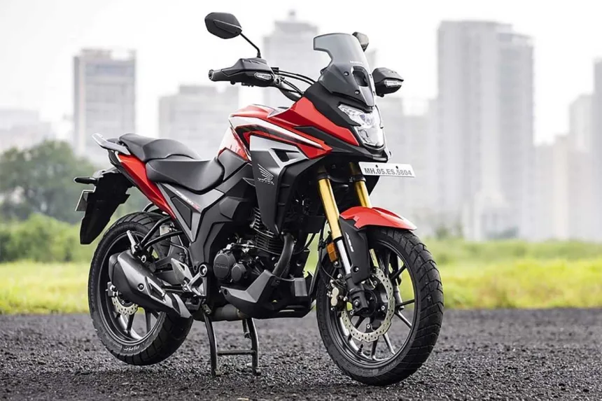 Honda CB200X in Sports Red parked on city street with adventure-style half-fairing
