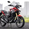 Honda CB200X in Sports Red parked on city street with adventure-style half-fairing