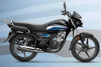 Honda CD 110 Dream in Black with Red parked on city street with chrome muffler cover