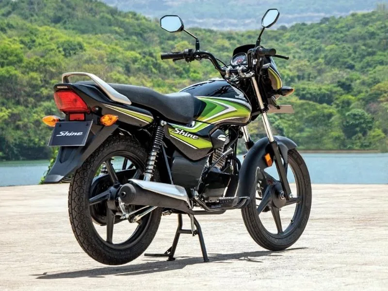 Close-up of Honda Shine 100 analog twin-pod instrument cluster with speedometer and fuel gauge