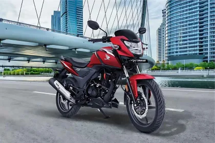 Honda SP160 motorcycle in Radiant Red Metallic parked on city street with LED headlamp