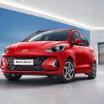 Hyundai Grand i10 Nios 2025 in Aqua Teal parked in city with projector headlights, showcasing stylish hatchback design