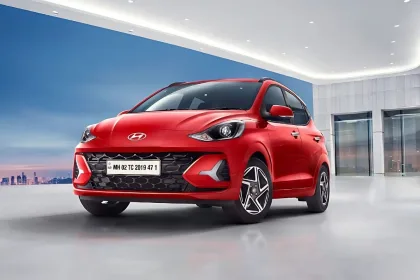 Hyundai Grand i10 Nios 2025 in Aqua Teal parked in city with projector headlights, showcasing stylish hatchback design