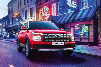 Hyundai Venue 2025 in Fiery Red parked in city with LED headlights, showcasing stylish compact SUV design