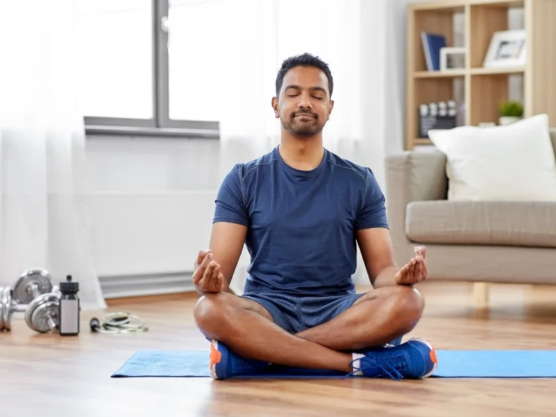 Person meditating in serene setting for stress-free morning, 2025
