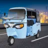 Piaggio Ape E-City FX Max 2025 in Green parked on city street with LED headlights and 3-seater cabin