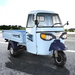 Piaggio Ape E-Xtra FX in Green parked on city street with LED headlights and spacious cargo body
