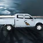 Tata Yodha Pickup in White parked on construction site with spacious load body and rugged design