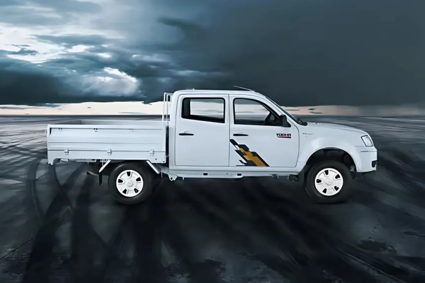 Tata Yodha Pickup in White parked on construction site with spacious load body and rugged design