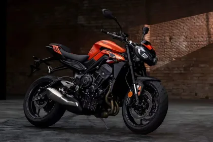 Triumph Street Triple 765 2025 in Carnival Red parked in city, showcasing aggressive naked bike design for Telugu riders