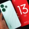 Xiaomi Redmi 13 5G smartphone displaying its sleek design in a tech store in 2025
