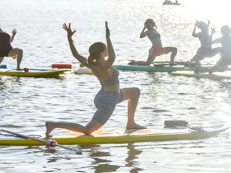 Participants practicing yoga on floating platforms during AP’s 2025 yoga event in Bejawada